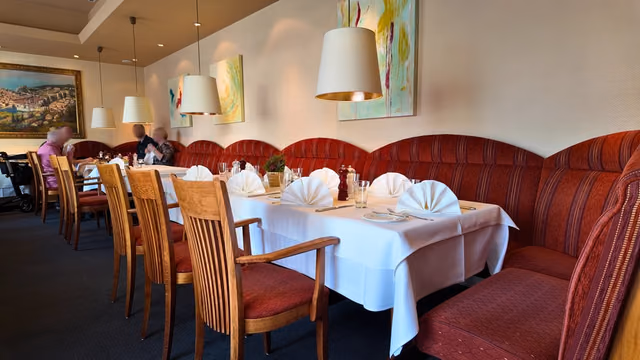 Long laid table along the row of red benches, with folded napkins at every setting