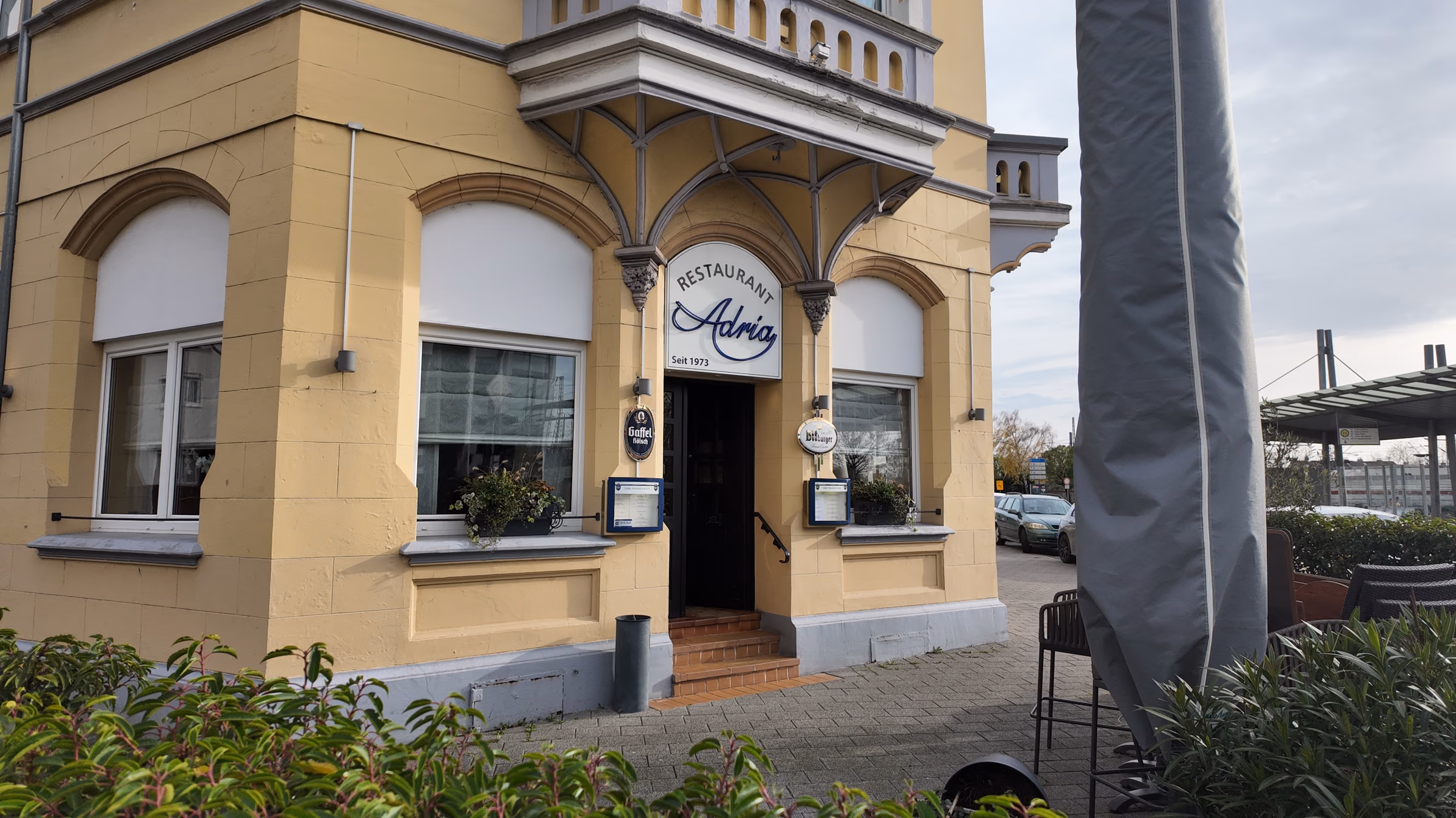 Außenansicht des Restaurant Adria: gelbe Gründerzeitfassade an der Straßenecke, über dem Eingang der blaue Schriftzug Restaurant Adria seit 1973